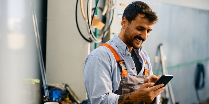 Car mechanic looking at his website on his phone