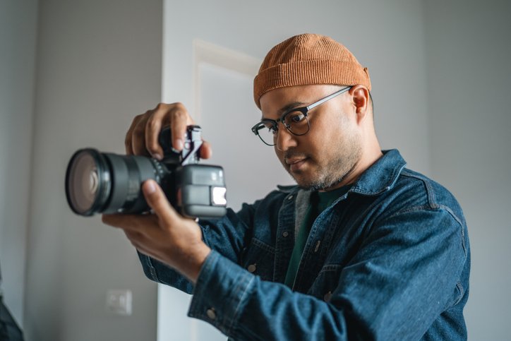 Websites for photographers - young photographer zooming in on his camera