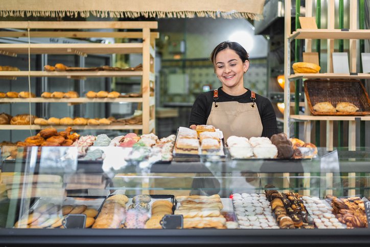 Websites for bakeries - young female baker at the front counter