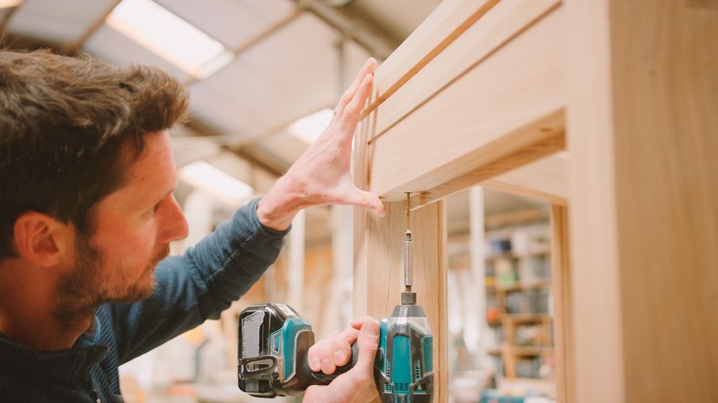 Websites for carpenters - carpenter at work building a cabinet